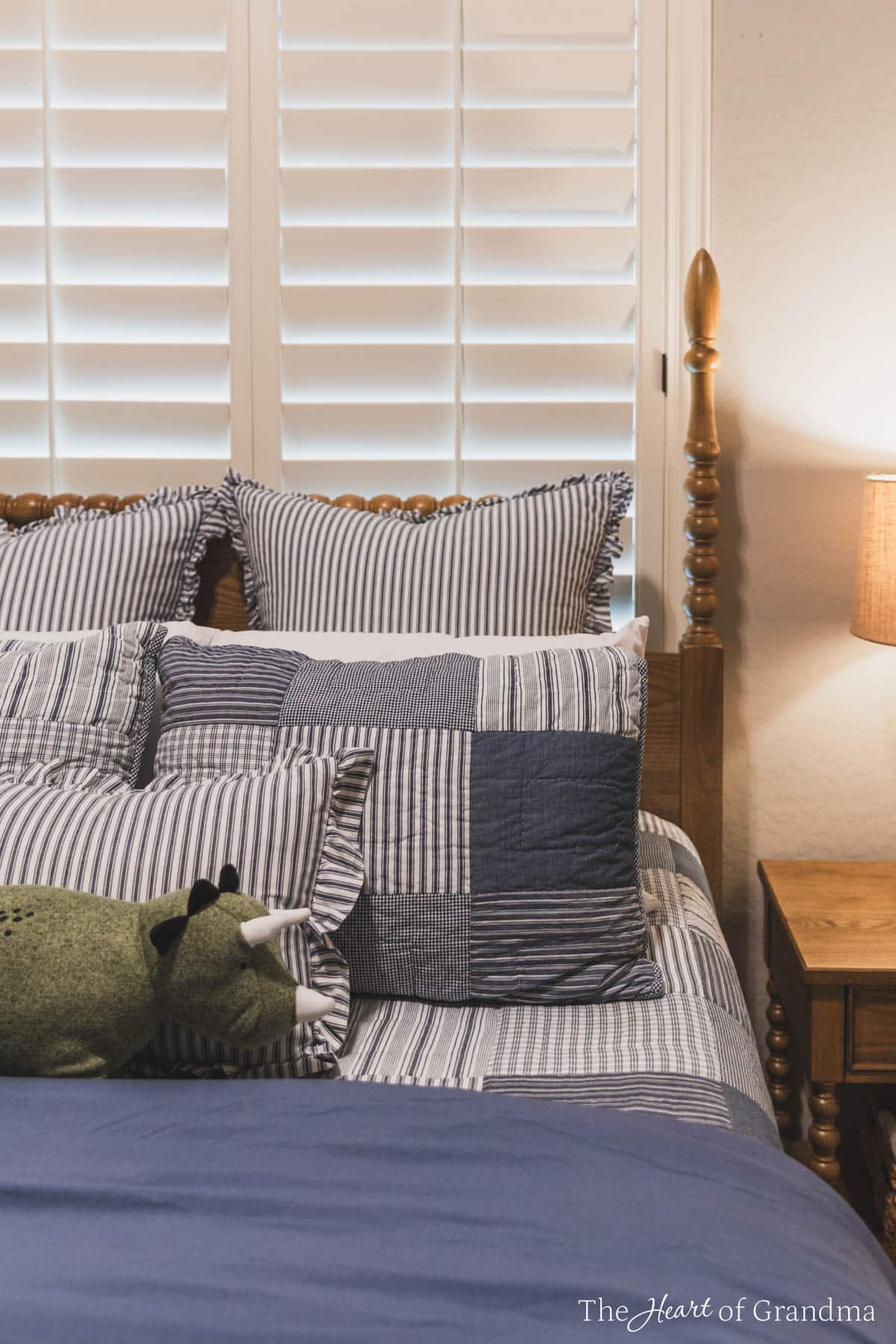 A spindle bed made up with a blue denim quilt.