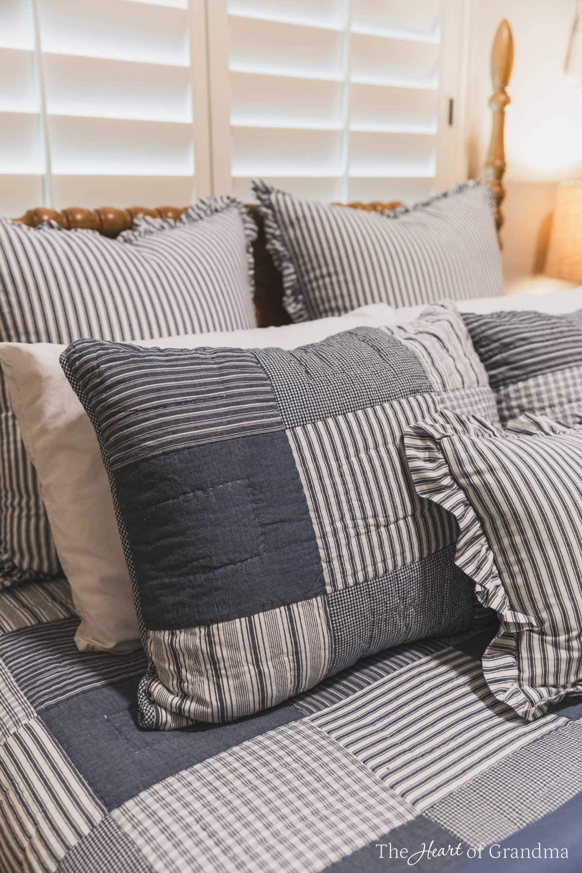 A spindle bed made up with a blue denim quilt.