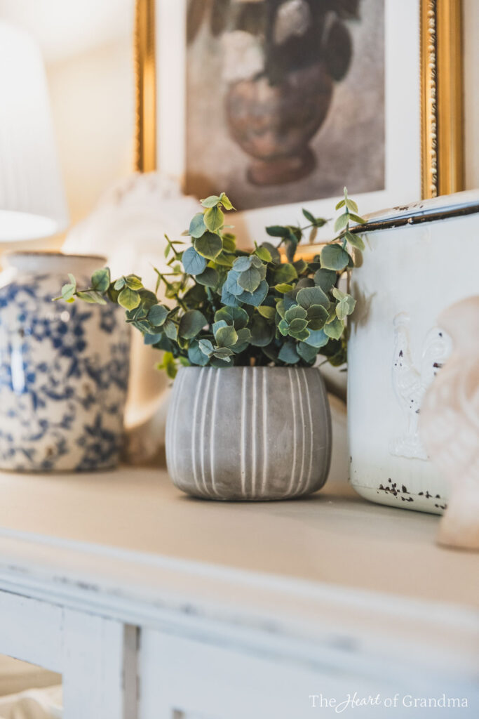 A small green plant sitting on top of a china cabinet.