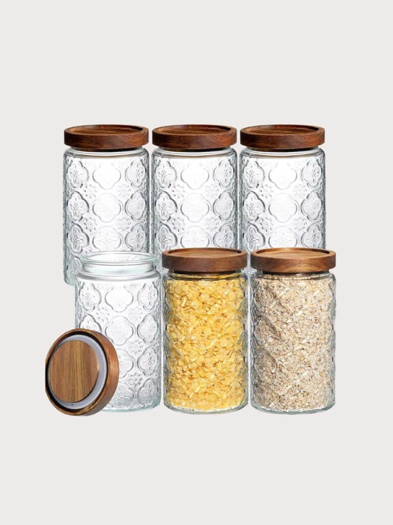Six fancy glass jars with wooden lids.