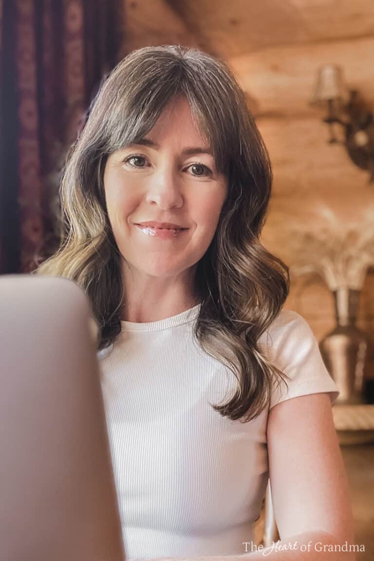 Kristine Underwood sitting behind her computer in a log home.