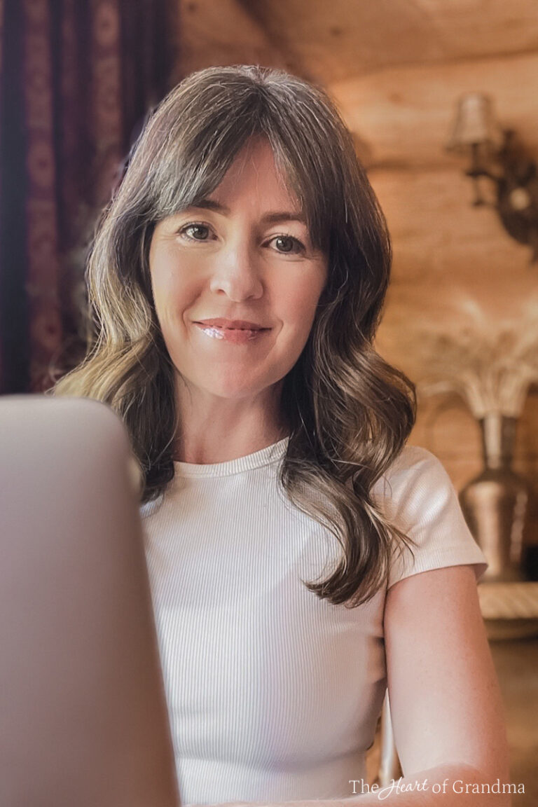 Kristine Underwood sitting behind her computer in a log home.