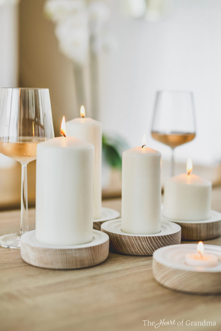 Several lit candles and two wine glasses sitting on a table.
