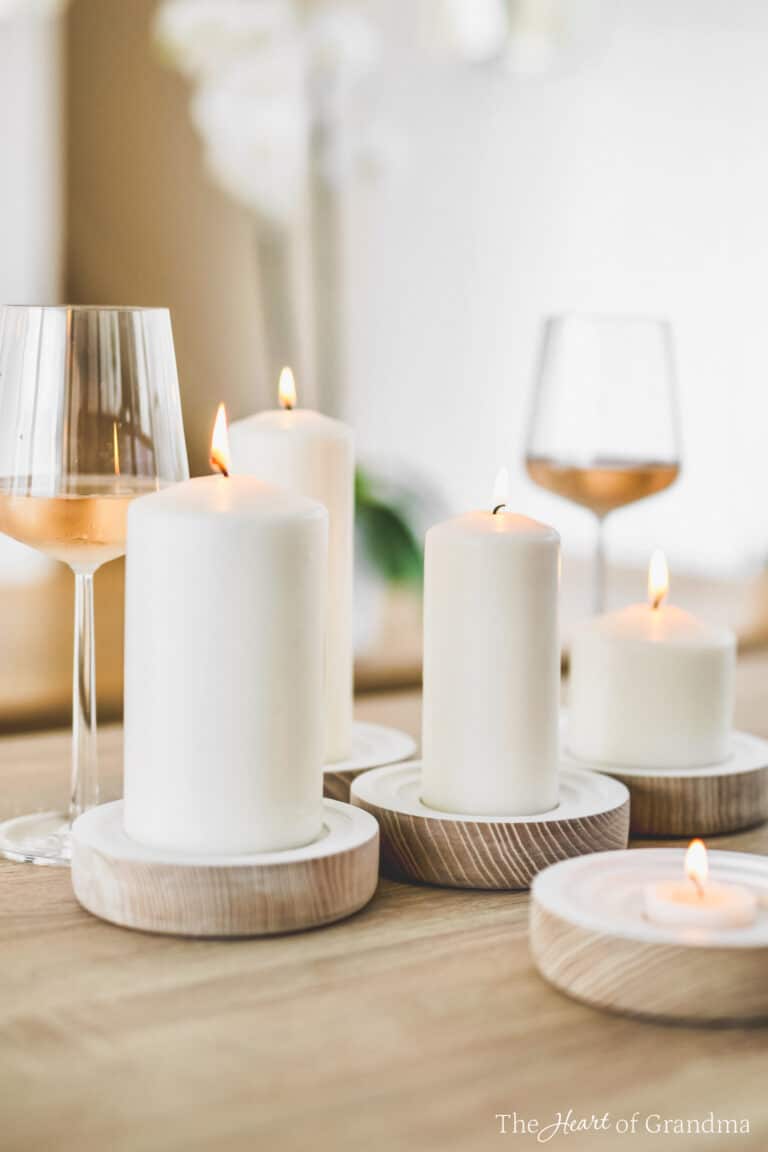 Several lit candles and two wine glasses sitting on a table.