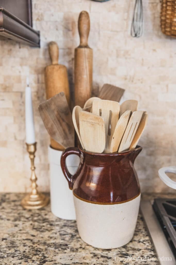 A crock full of wooden utensils sitting next to a stovetop.