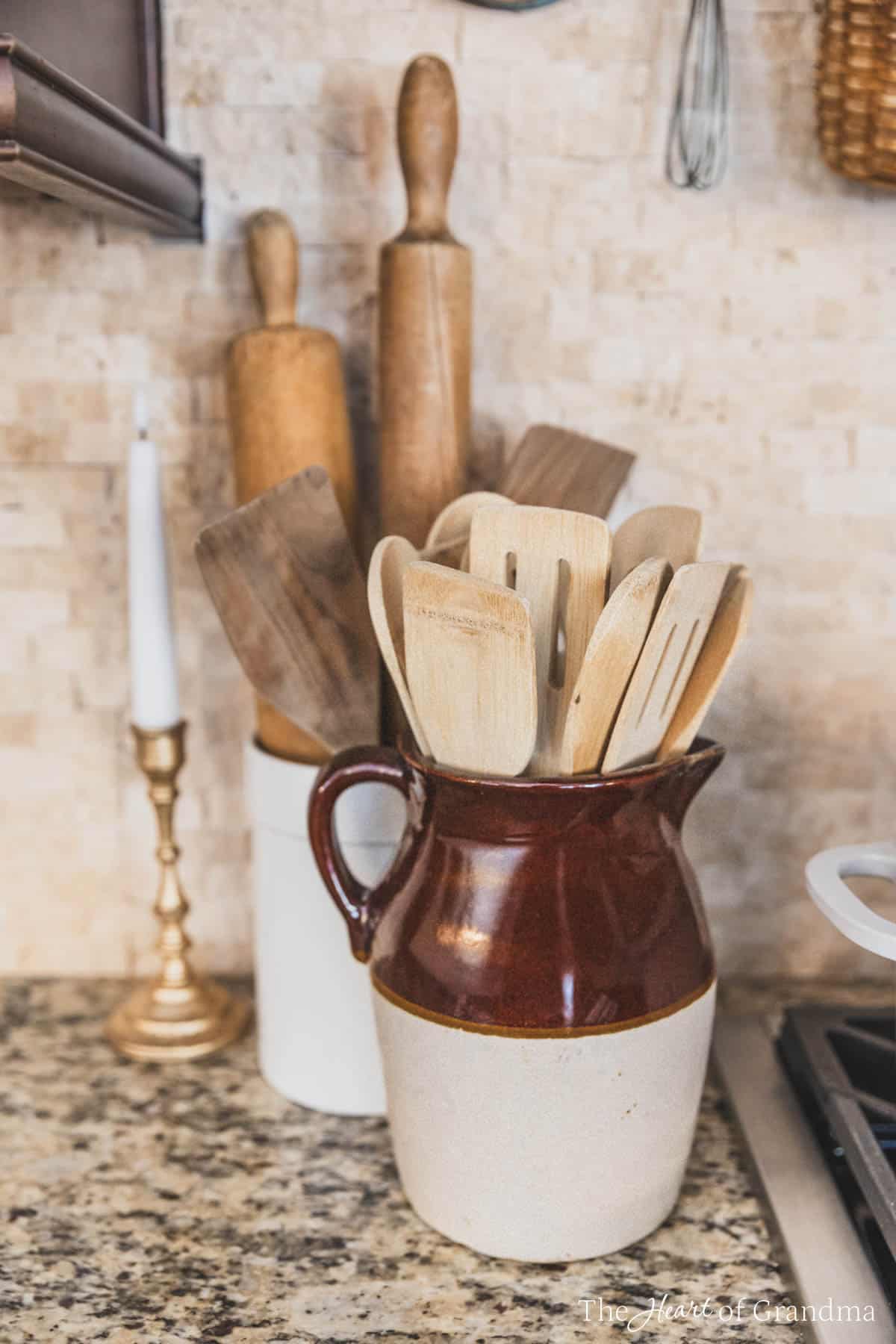 A crock full of wooden utensils sitting next to a stovetop.