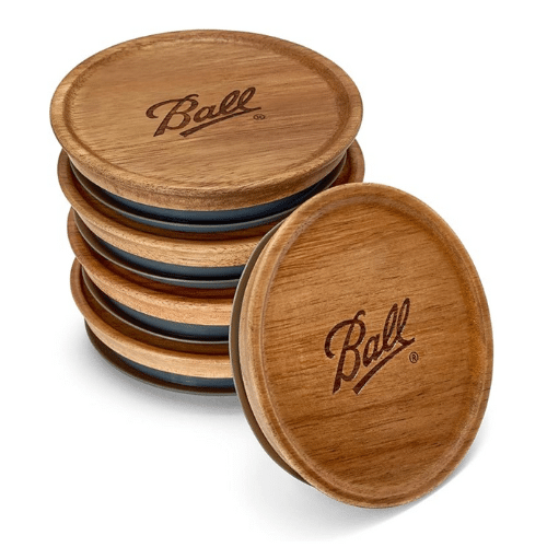 Wooden mason jar lids with "Ball" engraved on top.